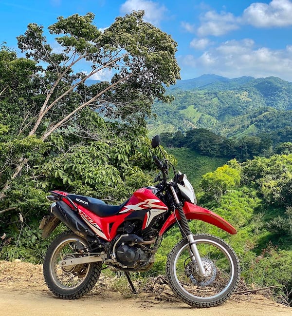 A red dirt bike above green hills in Colombia